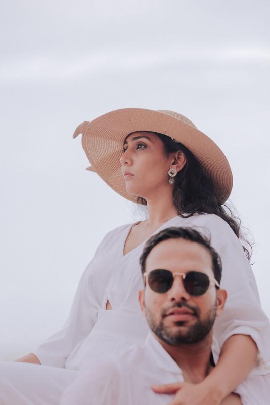 Couple on the beach, she in a wide-brimmed hat